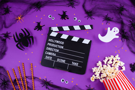 Movie Clapper board in spider webs, spiders, ghost, eyes on purple Lilac Background.の写真素材