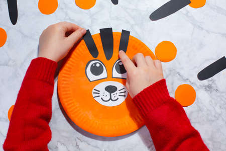 Tiger made of Paper Plate Tiger Craft. STEP 5 . Glue black stripesの写真素材