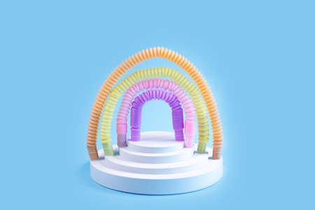 Colorful pop tubes in the form of a rainbow on blue background.の写真素材