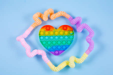 Multicolored bright plastic corrugated tube and pop it in the form of heartの写真素材