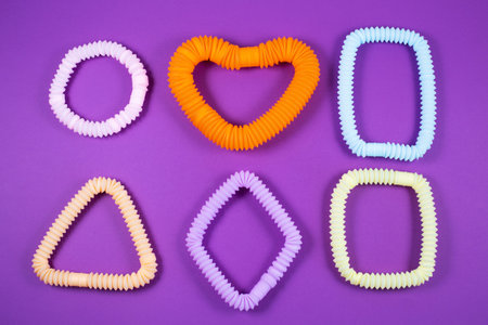 Multicolored bright tubes on blue background. Anti-stress sensory figet plastic toy.