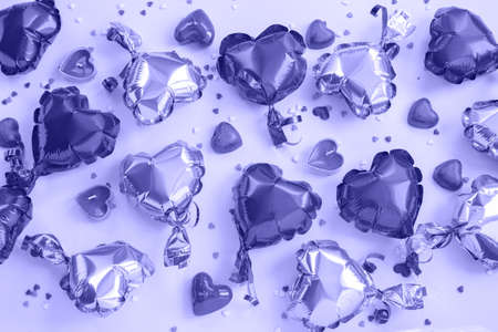 Air balloons heart shape, candies and candles on a violet color.の写真素材