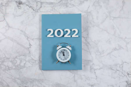 Number 2022 on diary with alarm on marble backgroundの写真素材