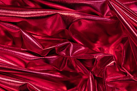 Elegant smooth satin folds close up. Color of year 2023 Viva Magenta. Luxury twisted fabric backplateの写真素材