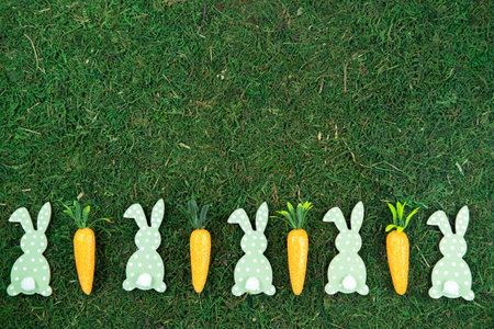 Easter background made of decorative carrots and bunny rabbits on natural organic texture,background.の写真素材