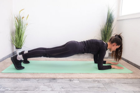 Workout at home.Athletic woman in sportswear doing stretching exercises at home in the living room.