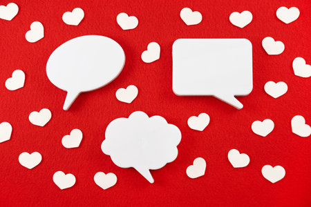 Chat icons with hearts on a red background. Virtual relationships and love online.