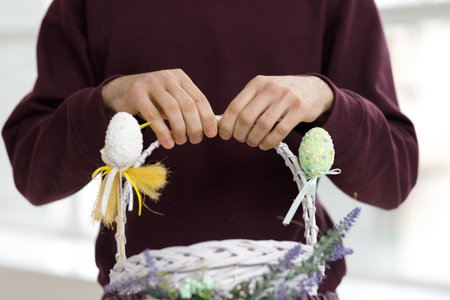 Easter toys. Easter basket with a decorative rabbit in the hands of a man. Blurred background, copy...