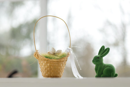 Easter toys. Easter basket with a decorative rabbit in the hands of a man. Blurred background, copy space.の写真素材