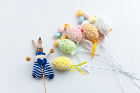 Easter toys. Wooden Easter eggs and rabbits on white background, copy space.の写真素材