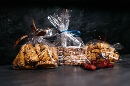 Homemade Italian Cantuccini with Almonds on a White Plate, side view. Crispy Almond Cookies. Dried viburnum. Dried viburnum on a dark background.の写真素材