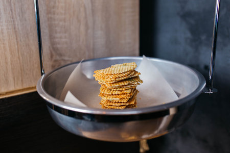 Round fluted baked Belgian waffles. Waffles on a metal plate. Wooden and gray background.