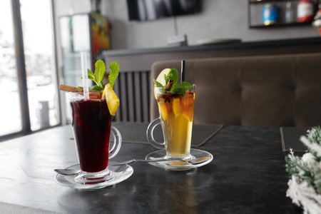 Mulled wine in a glass mug, hot red wine with orange and apple, spices with cinnamon, pouring into a glass on a table. beautiful background.の写真素材