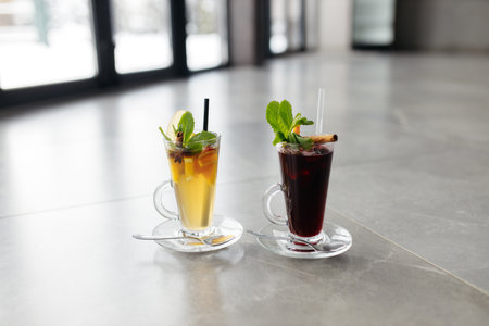 Mulled wine in a glass mug, hot red wine with orange and apple, spices with cinnamon, pouring into a glass. Beautiful gray background. copyspace.の写真素材