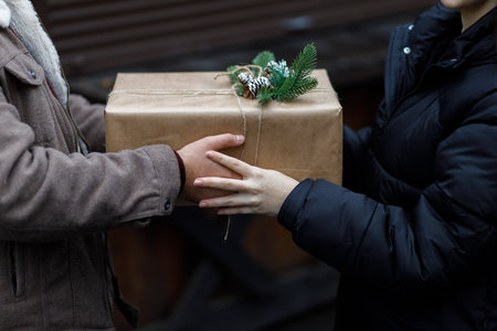 A couple exchange gifts. beautiful gift. New Year's decor. Preparation for the holiday. Gift on a dark background.の写真素材