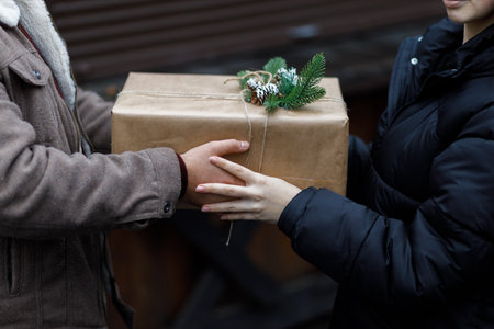 A couple exchange gifts. beautiful gift. New Year's decor. Preparation for the holiday. Gift on a dark background.の写真素材