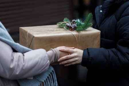 Friends exchange gifts. beautiful gift. New Year's decor. Preparation for the holiday. Gift on a dark background.の写真素材