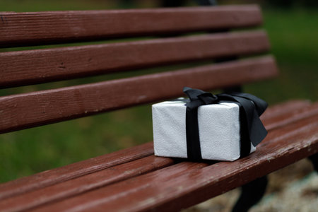 beautiful gift. New Year's decor. Preparation for the holiday. New Year's gifts on the wooden bench. close up.の写真素材