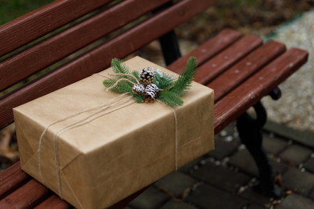 beautiful gift. New Year's decor with a Cristmas tree and knars. Preparation for the holiday. New Year's gifts on the wooden bench. close up.の写真素材