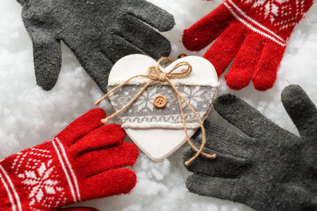 New Year toy. Warm gloves on a white background. Red and gray gloves. snowy background. close up.の写真素材