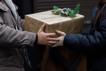 A couple exchange gifts. beautiful gift. New Year's decor. Preparation for the holiday. Gift on a dark background.の写真素材