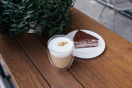 Cappuccino on the table. Delicious cappuccino in a glass cup near the cake.の写真素材