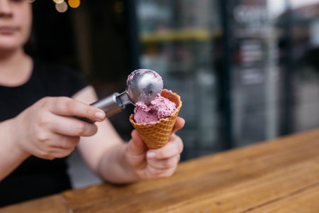 ice cream cones. Ice cream waffle cones. Waffle cone being held by a girl. Colorful cereal toppings for vibrance. perfect for hot summer days or winter.の写真素材