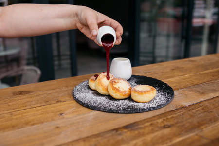Cheese pancakes, homemade traditional Ukrainian and Russian matches, selective focus. Cheesecakes on a plate. Cheese pancakes or cheesecakes with berry jam.の写真素材