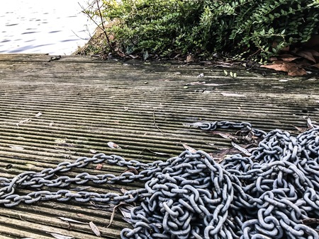 Chains on the floating wooden dock at the edge of the lake.の写真素材