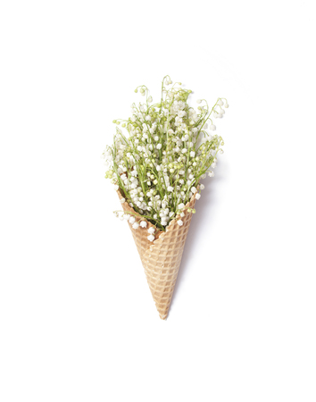 Waffle cone with white lilies of the valley isolated on white backgroundの写真素材