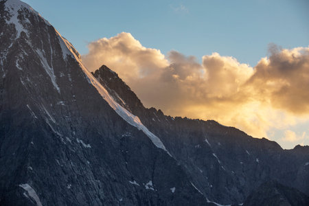 Beluha mountain in orange rays of the setting sun. Altai, Russia