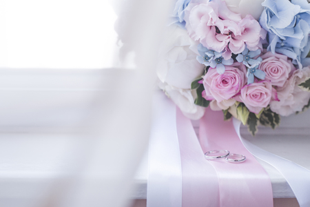 Wedding rings and bridal bouquet on window sillの写真素材