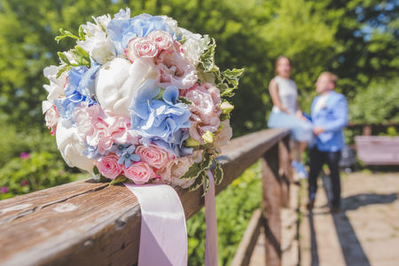 blurred silhouette newlyweds behind beautiful wedding bouquetの写真素材