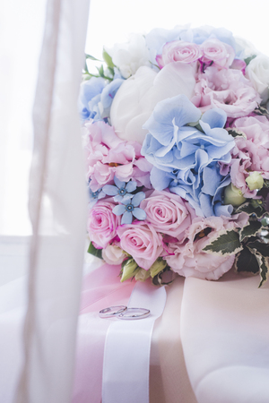 Wedding rings and bridal bouquet on window sillの写真素材