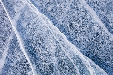 Cracks in ice of Baikal lake. Top view. Winter texture