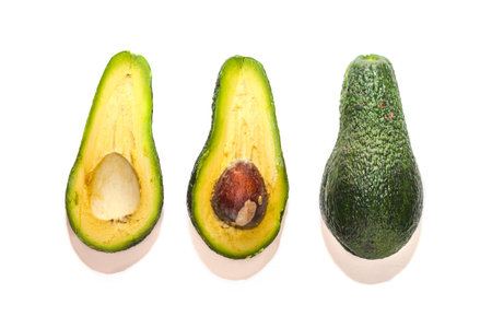 Whole and Halved Ripe Avocado on white background