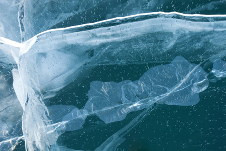 Cracks in turquoise ice of Baikal lake. Top view. Winter texture