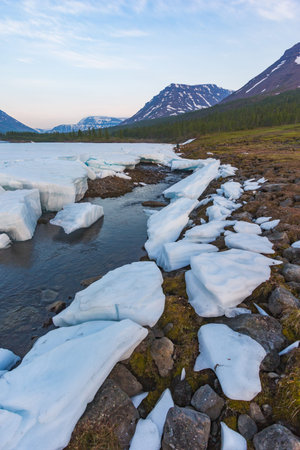 Snow and ice on the banks of the river Hoisey. Polar day on Putorana Plateau, Taimyr, Russia