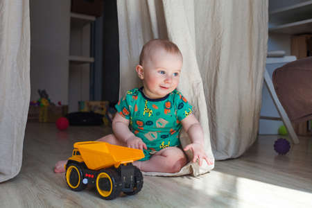 Eight-nine month baby boy portrait plays on the floorの写真素材