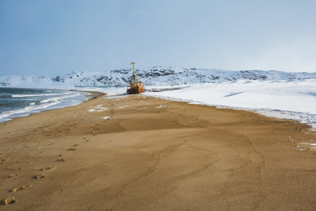 Ship on sandy shore near Teriberka, Barents Sea bay. Kola Peninsula landscape. Russia