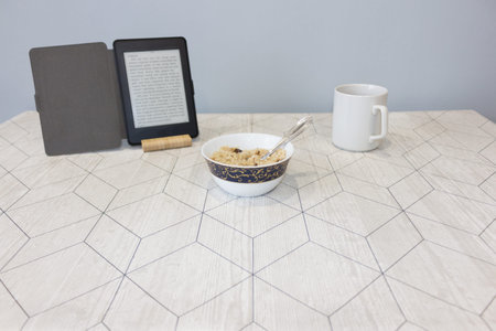 Electronic book and a cup of coffee on the table, background
