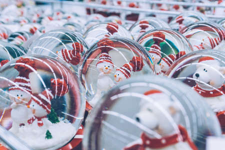 A lot of Christmas snow globes with snowman inside on the market. Christmas mood. Shoppingの写真素材
