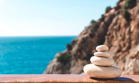 Zen relax background. A pyramid of stones on the beach in clear sunny weather. Background for meditation, yoga and massageの写真素材