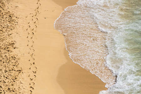 Beautiful empty beach from above with turquoise sea water and clean sand. Sea foam and waves.の写真素材