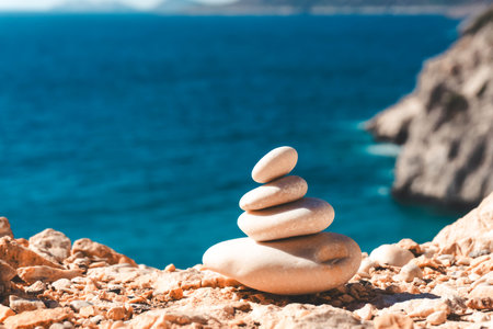 Zen relax background. A pyramid of stones on the beach in clear sunny weather. Background for...