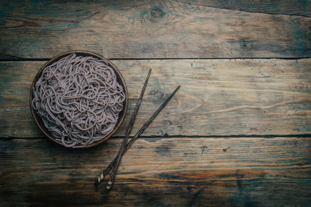 Soba noodles in a wooden bowl on a wooden background. Japanese style. Zen food. Copy space.の写真素材