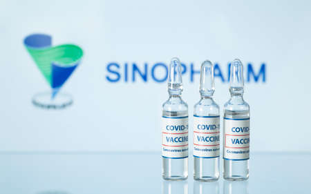 Concept of Chinese vaccine against COVID-19. Glass medical vials with liquid. Ampoules with coronavirus vaccine on a medical glass table. Selective focus. New York, USA - 14 December 2020のeditorial素材