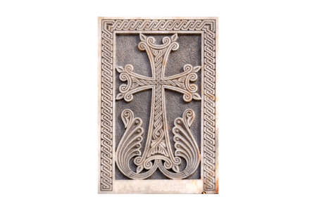Armenian Christian cross carved in stone isolated. Ancient ornamental christian cross on stone in churchの写真素材