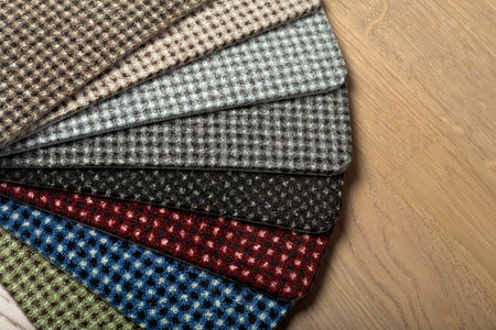 Types and samples of carpets in different colors on wooden floor backgrond. Carpets for rooms,...