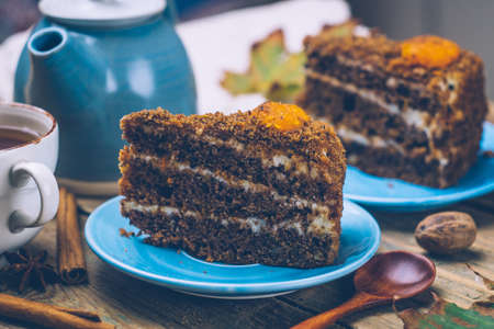Carrot cake (homemade desserts) whith cinnamon sticks and decorated with spices and cup of tea on wooden background.の写真素材